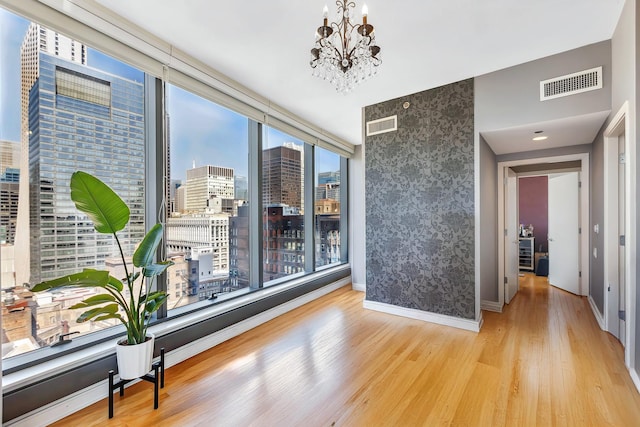 dining room featuring a view of city, visible vents, an inviting chandelier, and wood finished floors