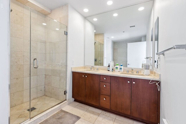 bathroom featuring recessed lighting, a sink, tile patterned flooring, and a stall shower