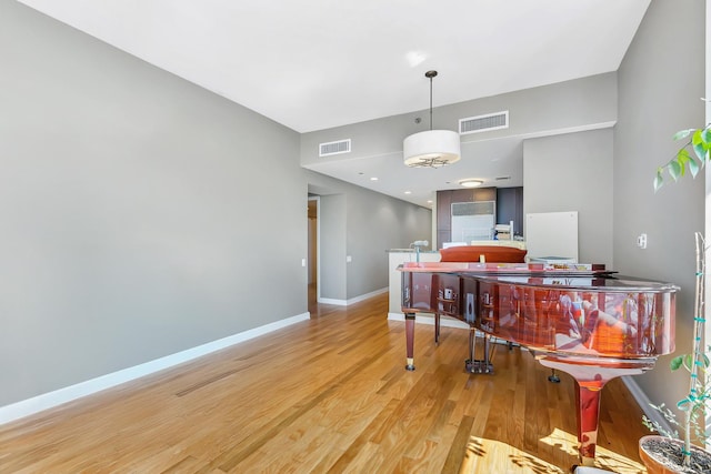 dining space with visible vents, light wood-style flooring, and baseboards