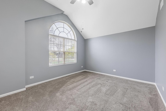 carpeted spare room featuring ceiling fan, vaulted ceiling, and baseboards