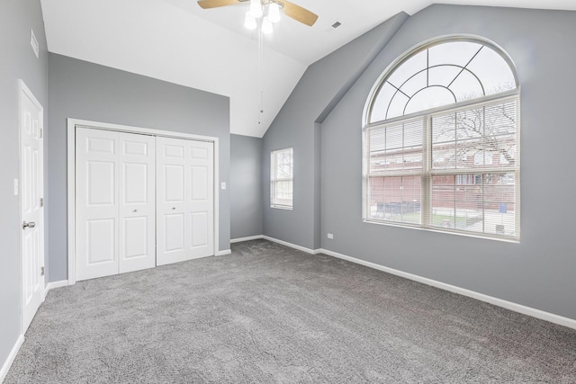 unfurnished bedroom with lofted ceiling, carpet, baseboards, and a closet