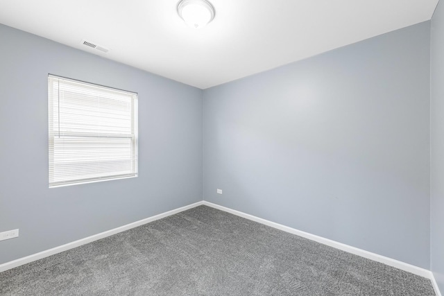 empty room featuring carpet, visible vents, and baseboards
