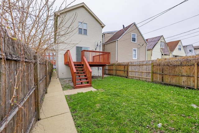 back of property featuring a deck, a yard, stairs, and a fenced backyard