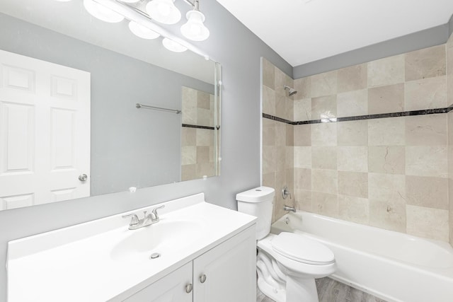 full bath featuring wood finished floors, toilet, shower / bath combination, and vanity