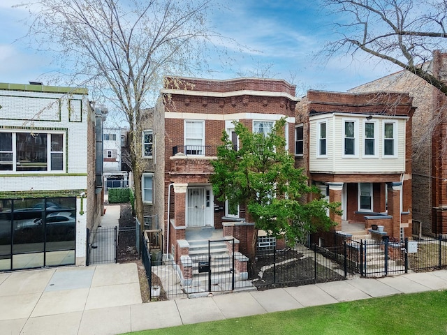view of property featuring a gate, brick siding, and a fenced front yard