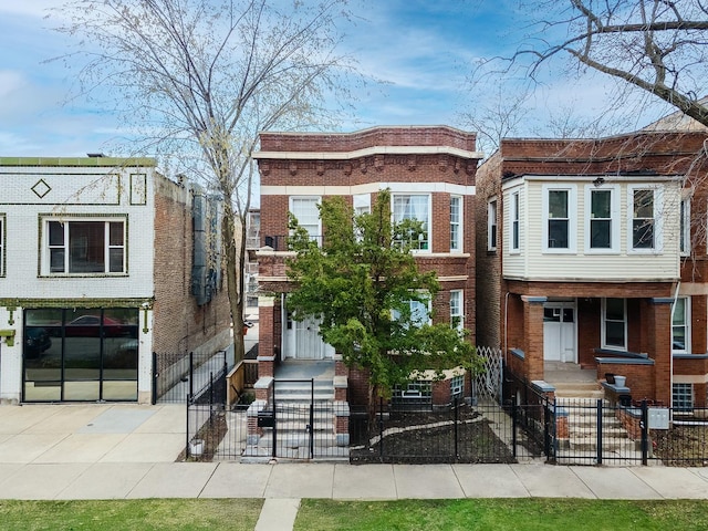 townhome / multi-family property featuring a gate, brick siding, and a fenced front yard