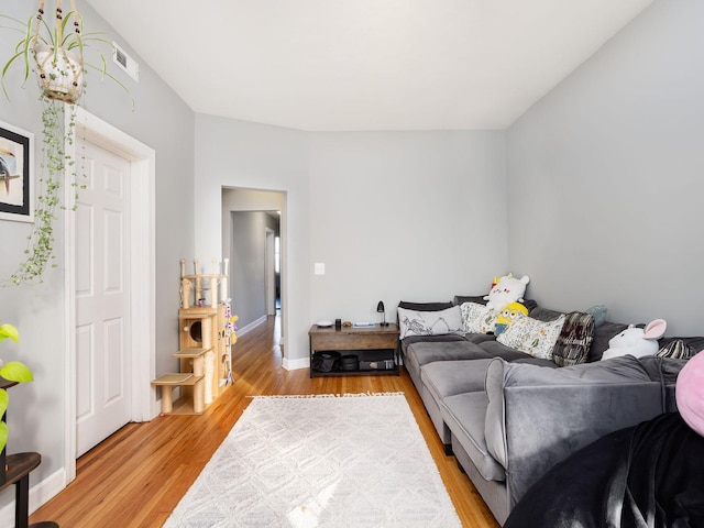 living area with visible vents, light wood finished floors, and baseboards