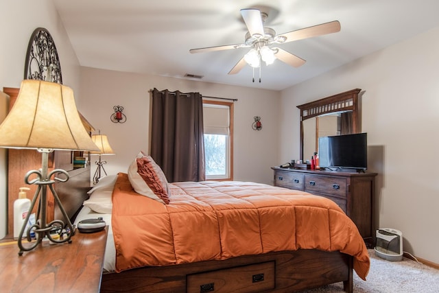 carpeted bedroom featuring baseboards, a ceiling fan, and visible vents