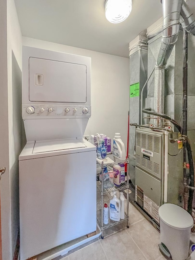 laundry area with stacked washer / dryer, heating unit, and laundry area