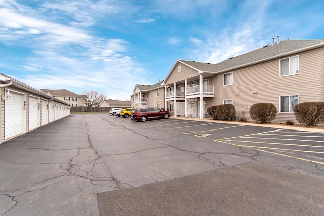 uncovered parking lot featuring a residential view and community garages