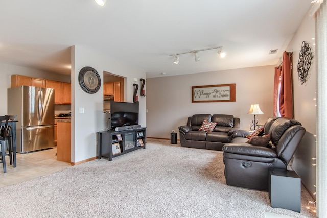 living area with rail lighting, light carpet, visible vents, and baseboards