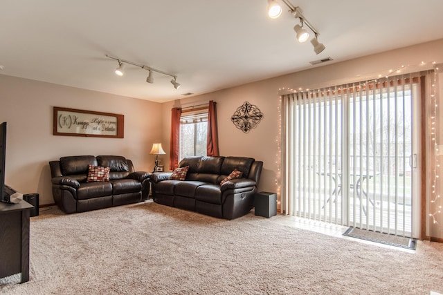 carpeted living room with track lighting and visible vents