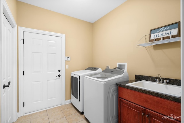 clothes washing area featuring washer and clothes dryer, cabinet space, light tile patterned floors, and baseboards