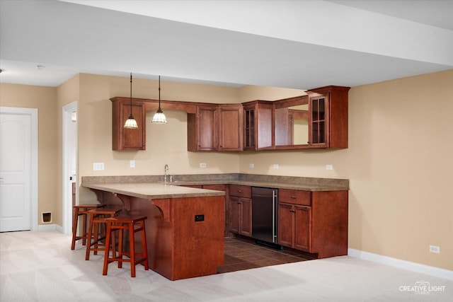 kitchen with a peninsula, a kitchen breakfast bar, glass insert cabinets, and baseboards