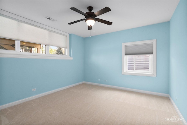 empty room featuring carpet, baseboards, and a ceiling fan