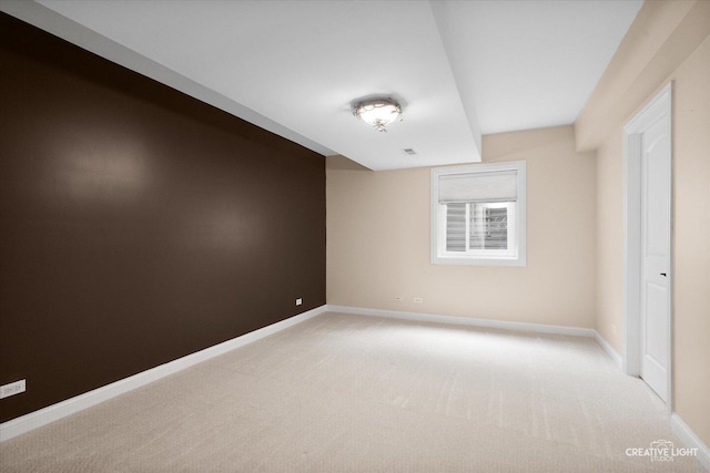 unfurnished room featuring light colored carpet and baseboards