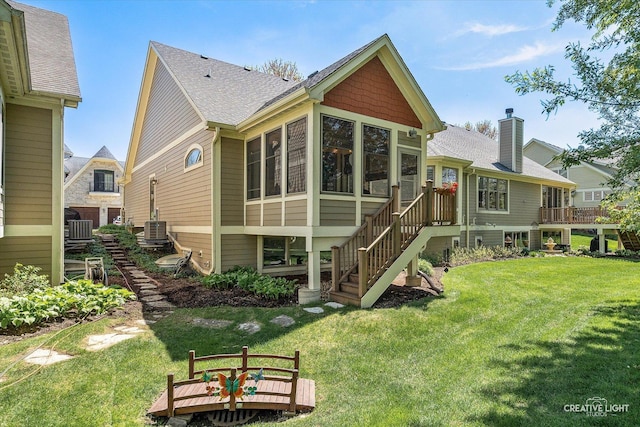 back of house with a sunroom, a lawn, and central AC