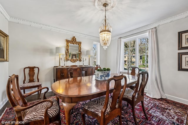 dining area featuring baseboards, ornamental molding, and a chandelier
