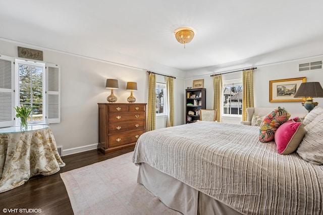 bedroom featuring baseboards, wood finished floors, and visible vents