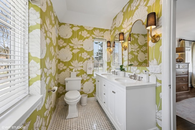 full bathroom featuring baseboards, toilet, wallpapered walls, and a sink