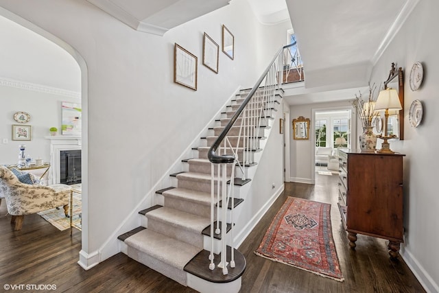 stairs featuring ornamental molding and wood finished floors