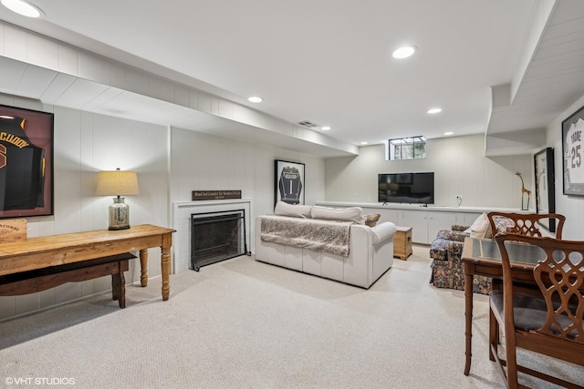 living area featuring recessed lighting, light carpet, and a fireplace