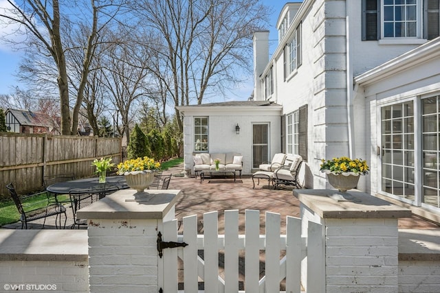 view of patio with an outdoor hangout area, a gate, and fence private yard