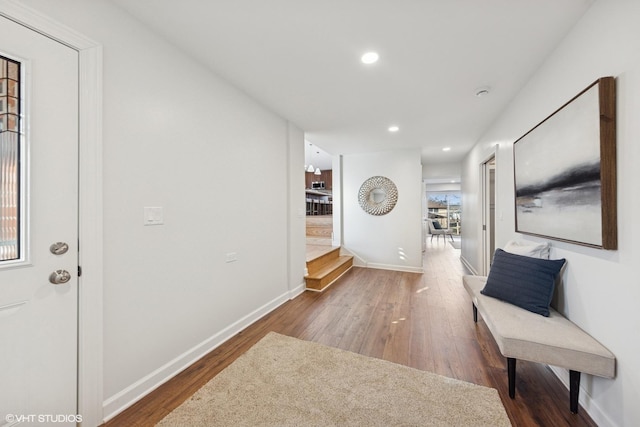 hall featuring baseboards, wood finished floors, recessed lighting, and stairway