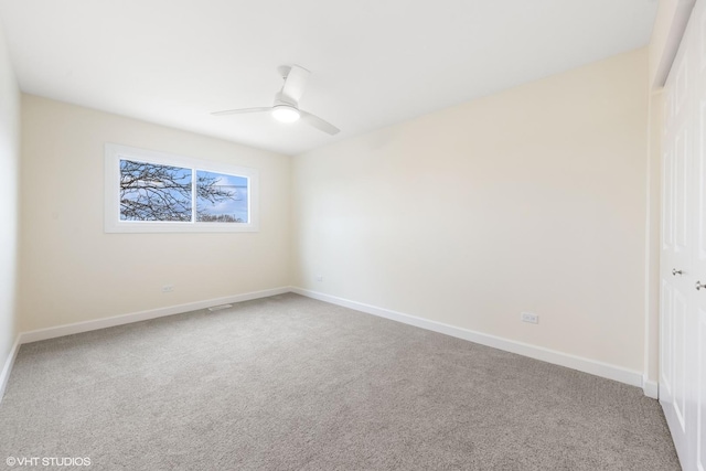 empty room featuring carpet, baseboards, and ceiling fan