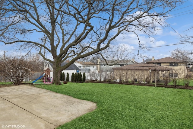view of yard with fence and a playground