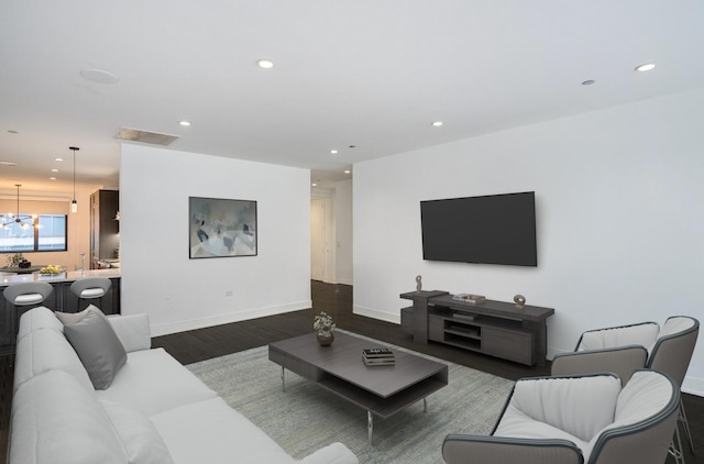 living area featuring dark wood-style floors, visible vents, baseboards, recessed lighting, and a notable chandelier