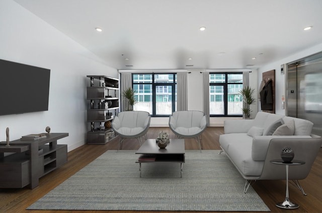 living room with elevator, wood finished floors, and recessed lighting