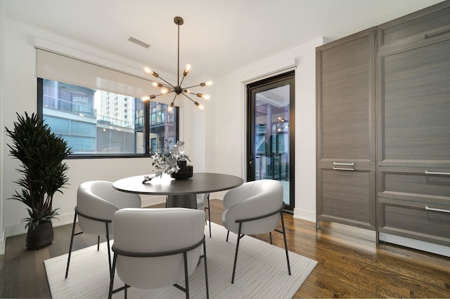dining room featuring dark wood finished floors, baseboards, a notable chandelier, and visible vents