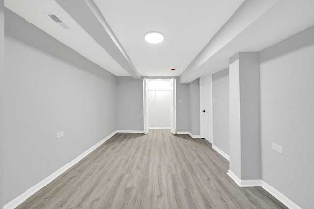spare room featuring light wood finished floors, baseboards, and visible vents