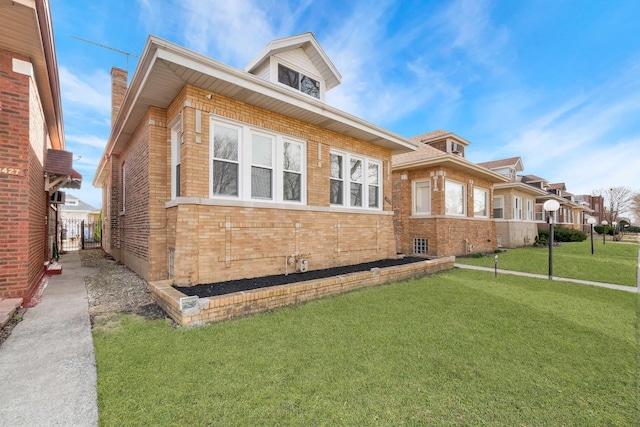 view of front of house featuring brick siding and a front yard