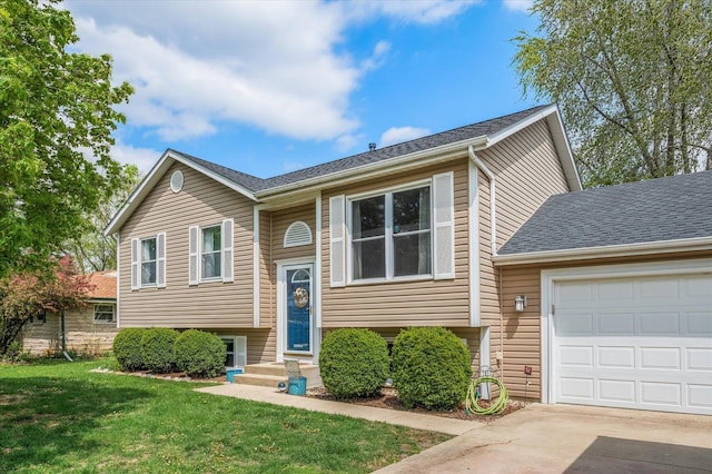 raised ranch with roof with shingles, an attached garage, driveway, and a front yard