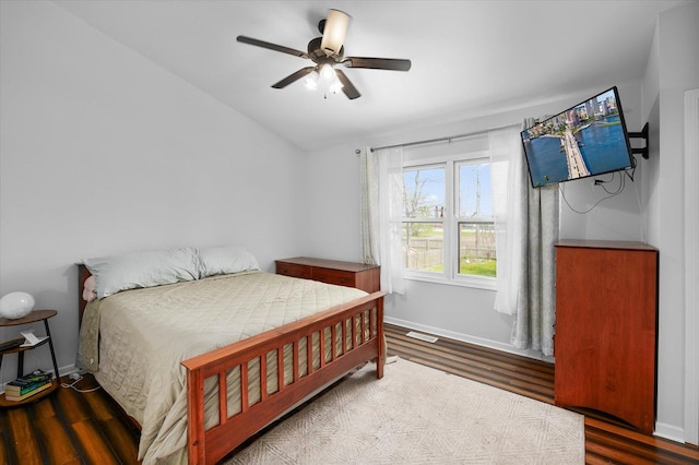 bedroom with baseboards, ceiling fan, vaulted ceiling, and wood finished floors