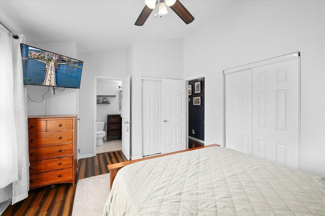 bedroom featuring connected bathroom, a ceiling fan, multiple closets, and wood finished floors