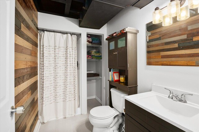 full bathroom with vanity, a shower with curtain, toilet, and wood walls