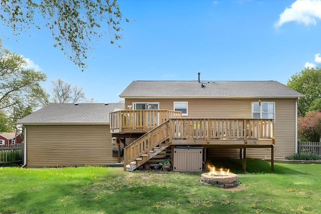 back of house with stairway, a deck, a fire pit, and a lawn