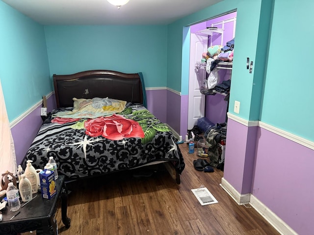 bedroom with visible vents, baseboards, wood finished floors, and a closet