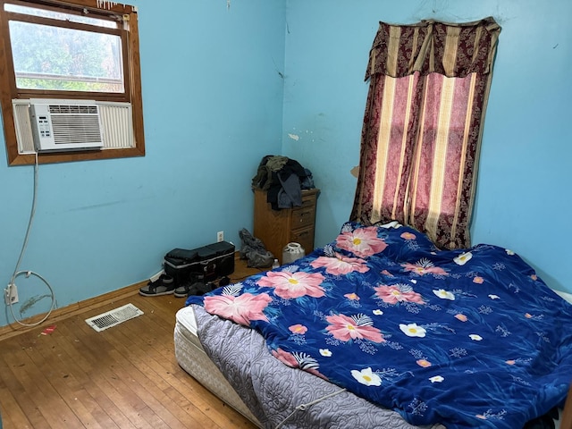 bedroom featuring cooling unit, visible vents, and wood-type flooring