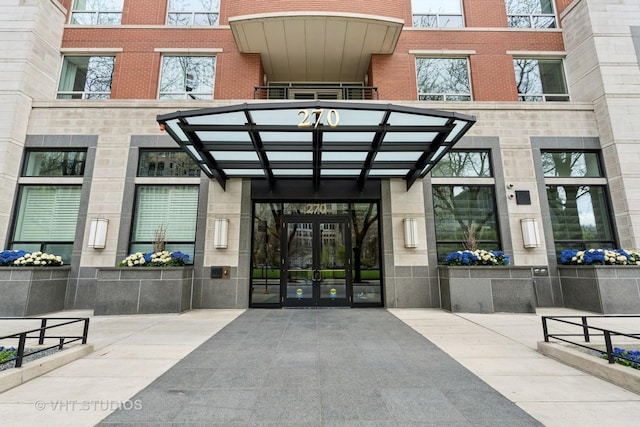 view of exterior entry featuring brick siding, french doors, and stone siding