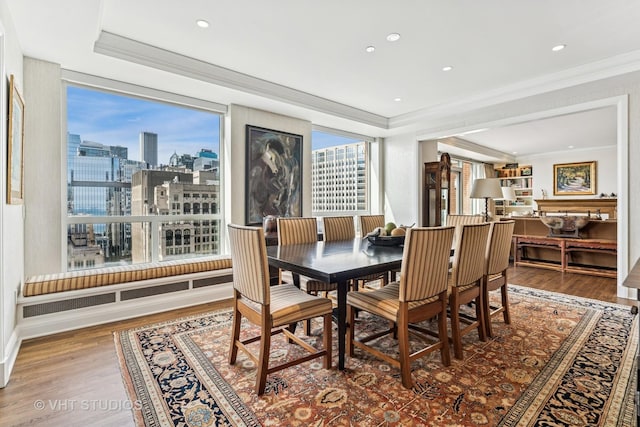 dining room featuring crown molding, wood finished floors, and a tray ceiling