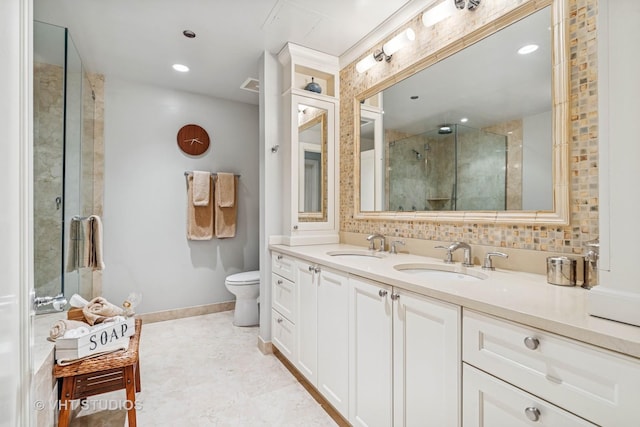 bathroom featuring double vanity, a sink, a stall shower, and toilet
