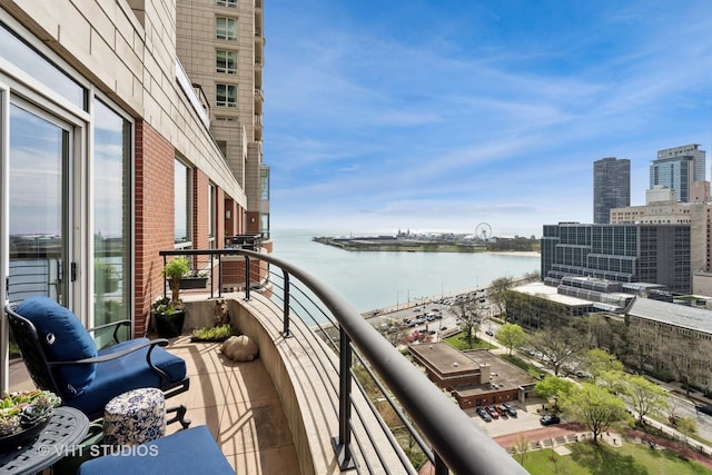 balcony featuring a water view and a city view