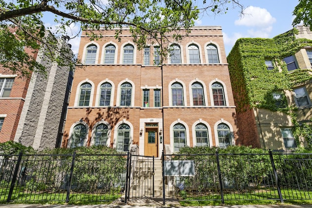 view of front of house with brick siding, a gate, and a fenced front yard