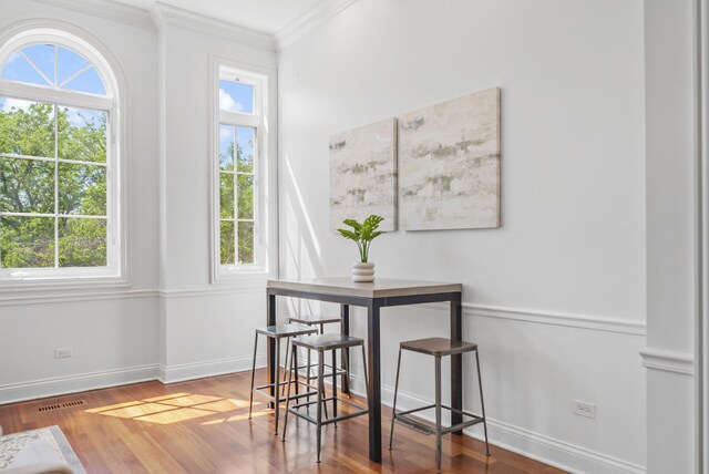 dining room featuring ornamental molding, wood finished floors, and baseboards