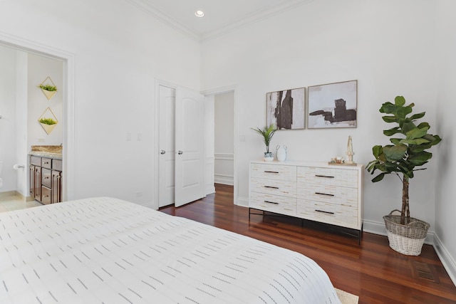 bedroom with baseboards, dark wood-type flooring, crown molding, recessed lighting, and ensuite bath
