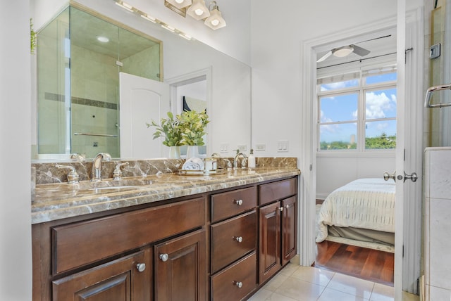 bathroom with a stall shower, double vanity, tile patterned flooring, and ensuite bathroom